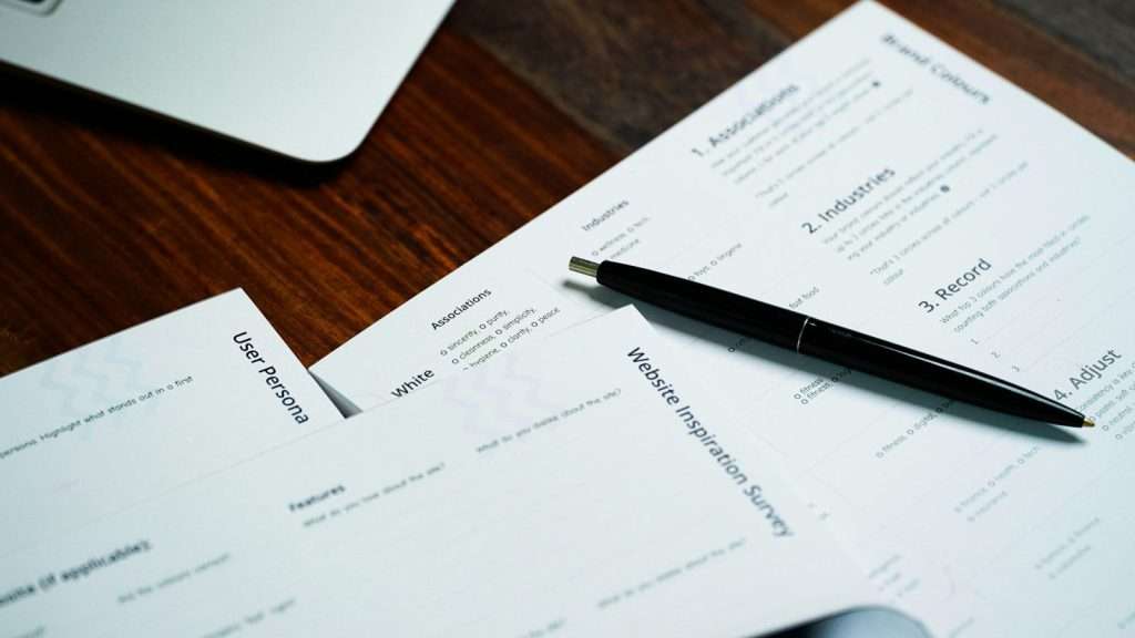 Pen resting on a pile of documents ready for notarisation