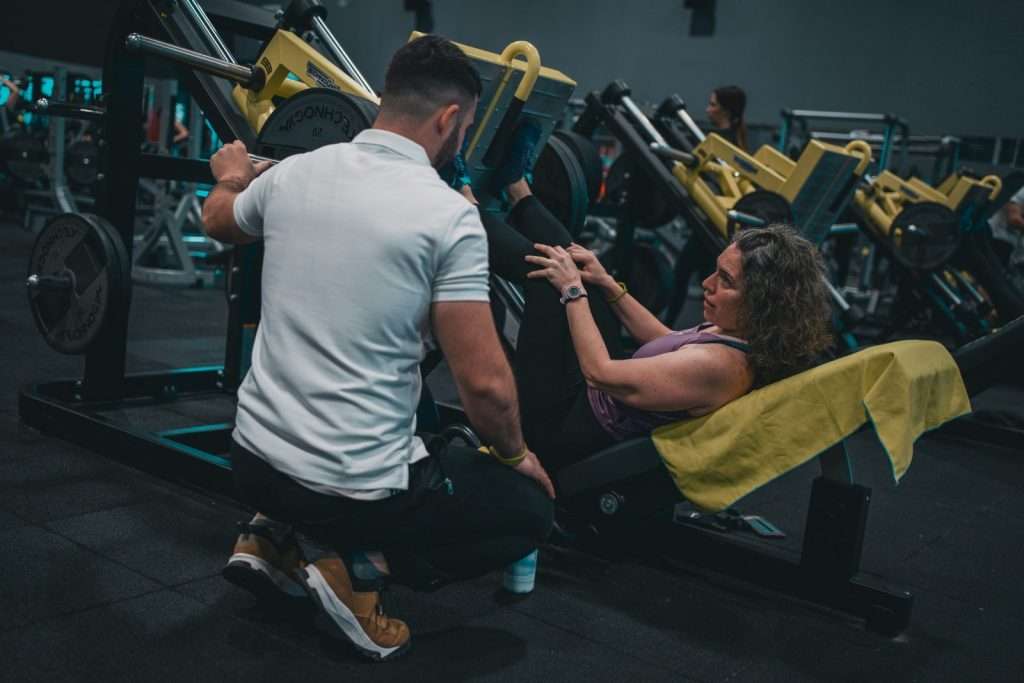 Personal trainer working with client in gym