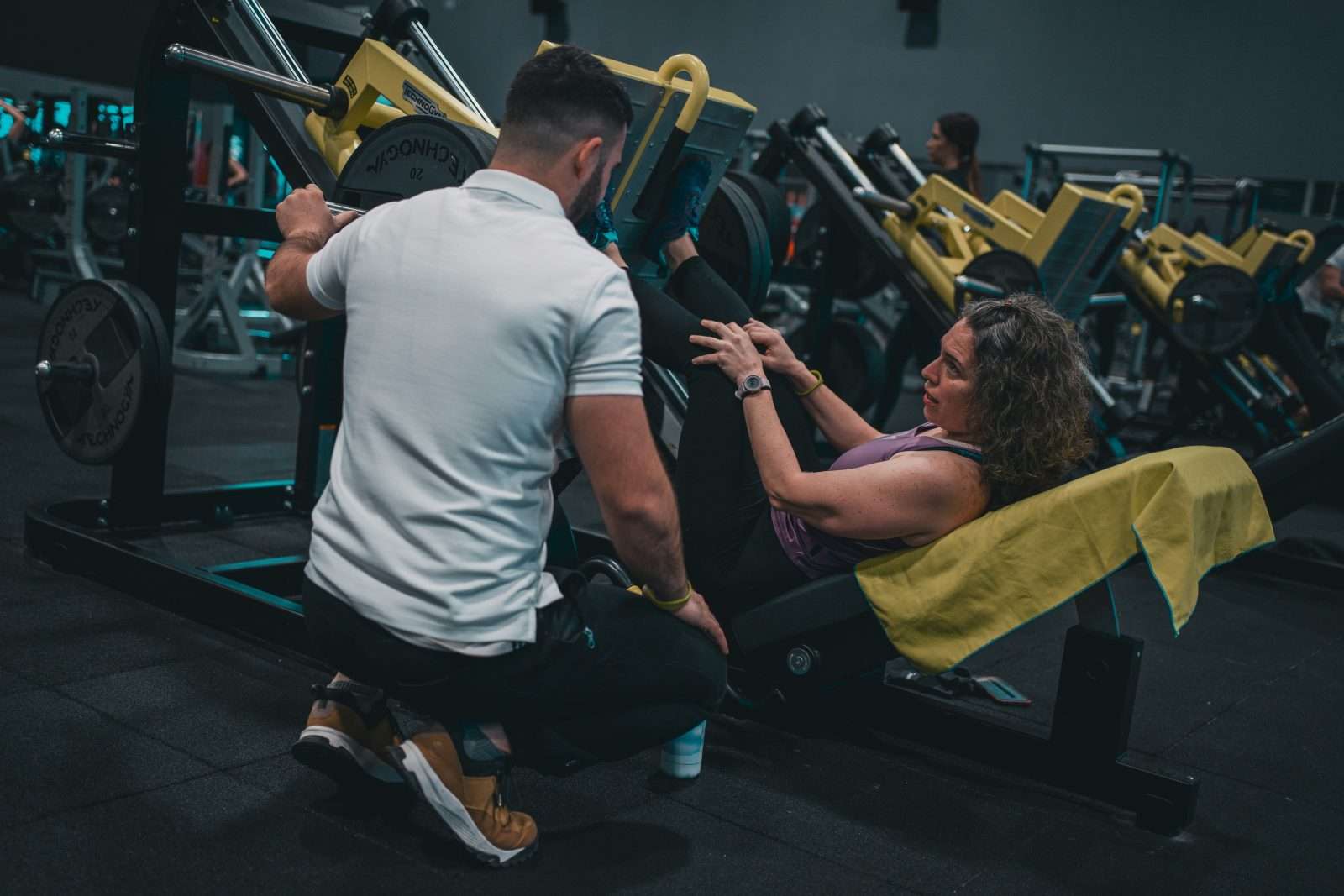 Personal trainer working with client in gym