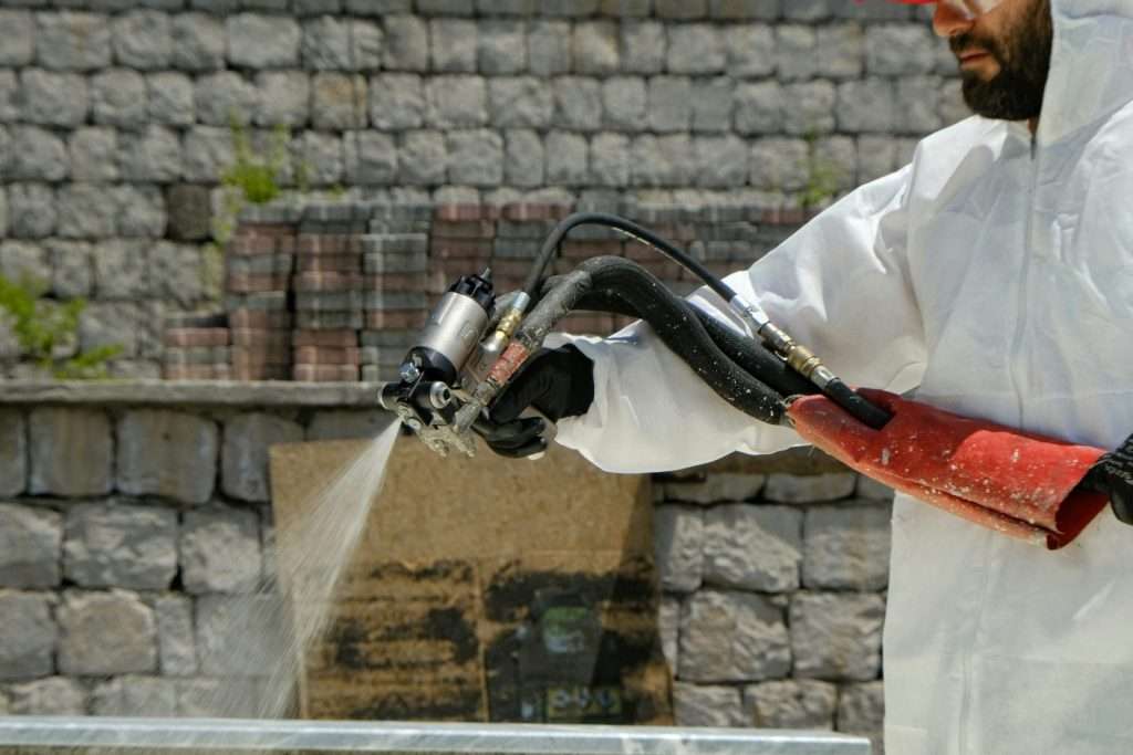 UK asbestos removal specialist in white coverall PPE