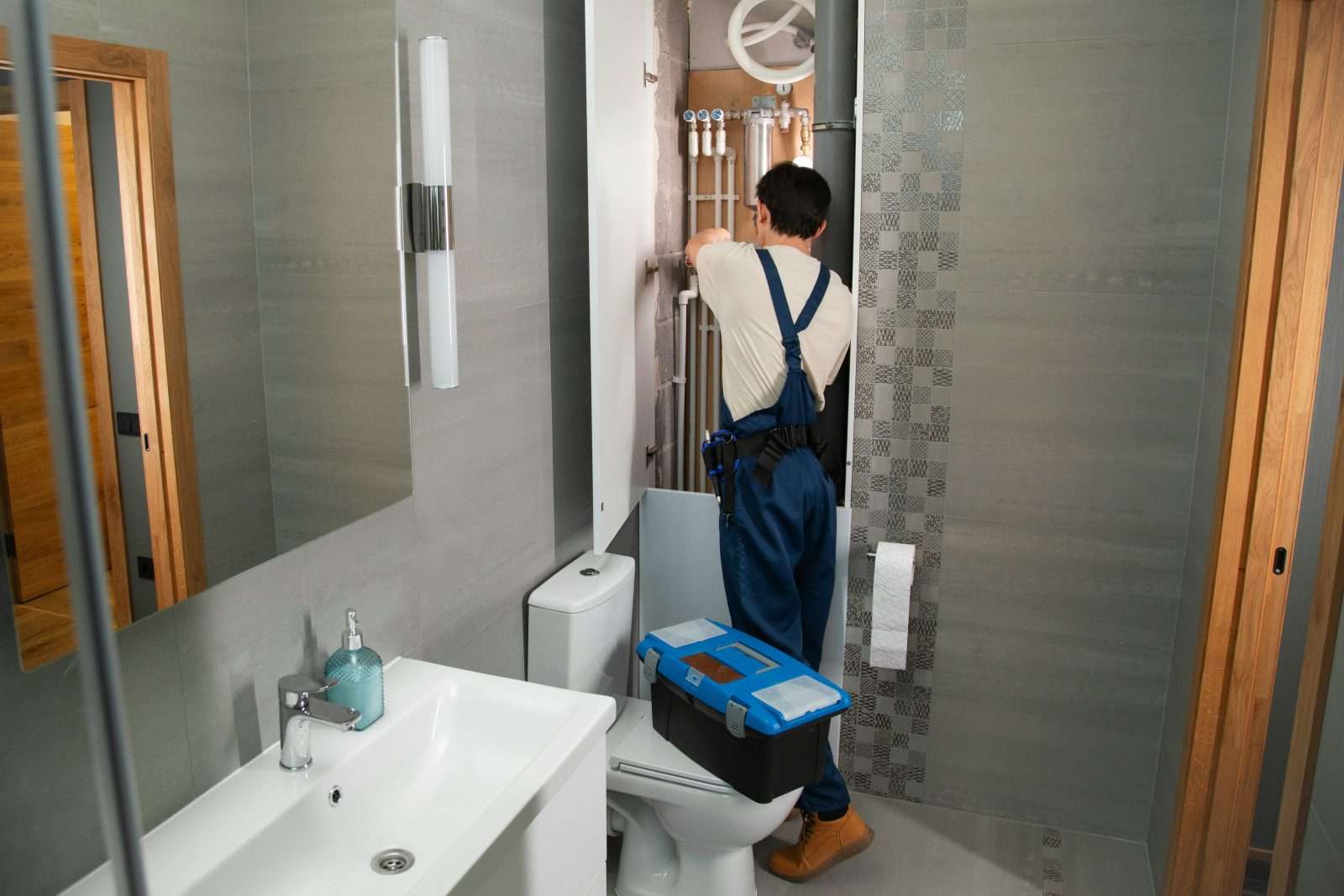 UK plumber repairing bathroom plumbing pipes
