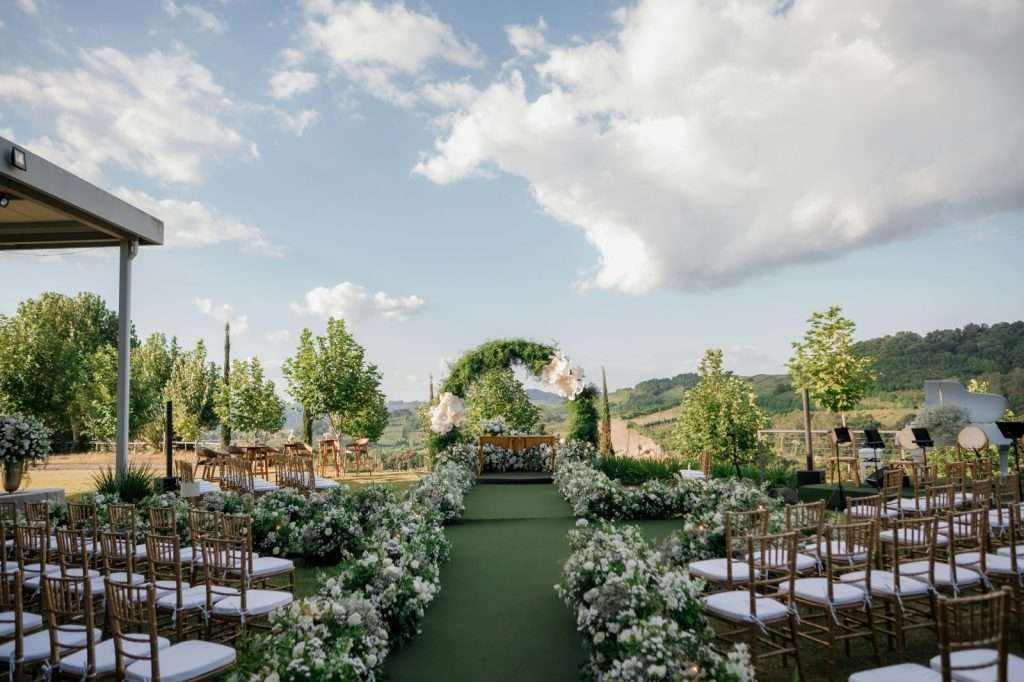 Outdoor wedding ceremony setup with chairs and floral decorations.