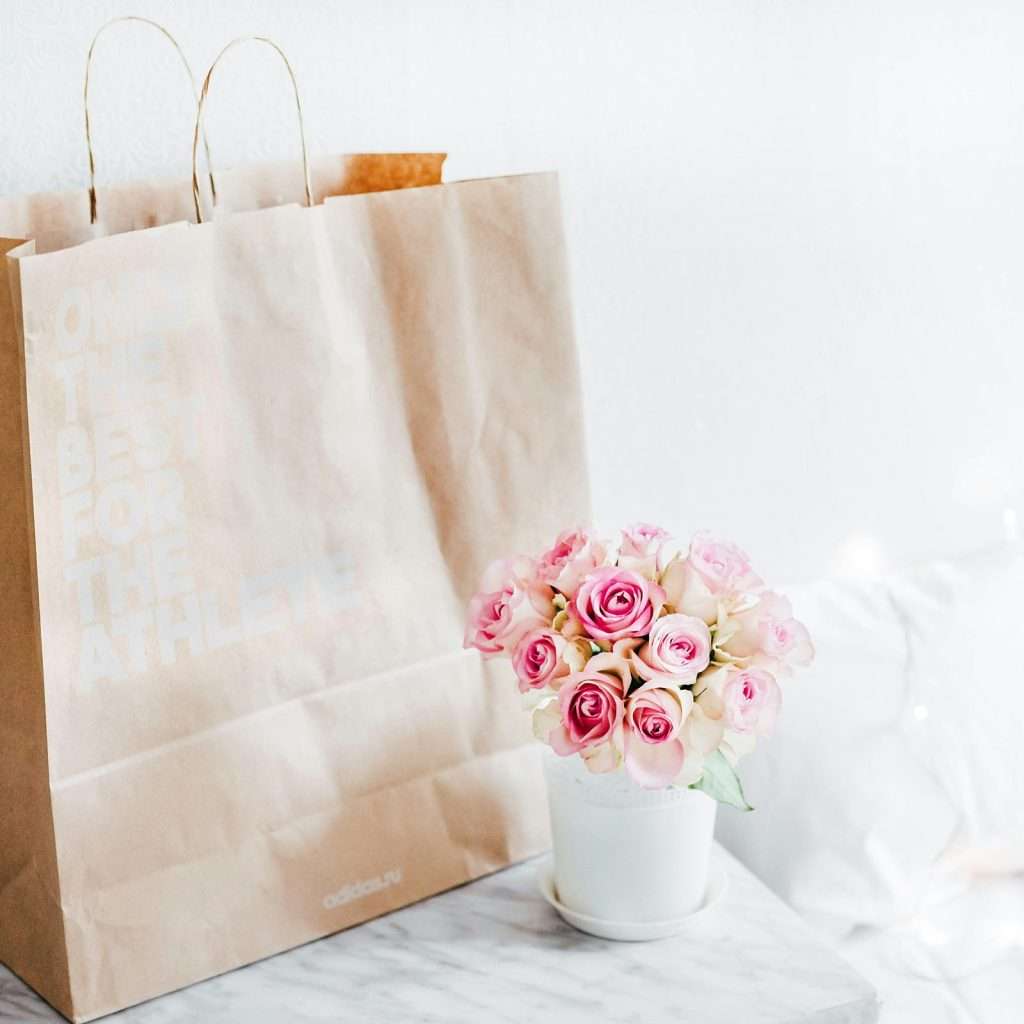 E-commerce, flowers beside brown paper bag